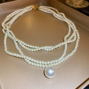 Elegant multi-layer baroque pearl necklace featuring a large round pearl pendant
