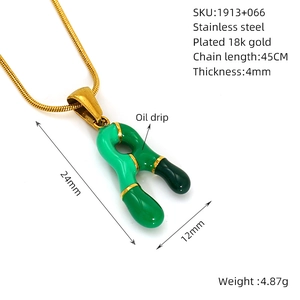 Dettaglio del ciondolo lettera R in acciaio inossidabile placcato oro 18k e smalto verde