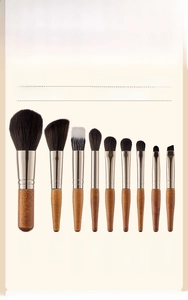Detail view of 9 mini makeup brushes with black fiber bristles and natural wood handles
