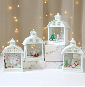 Detailed view of white Christmas house lanterns with Santa and reindeer motifs in warm bokeh