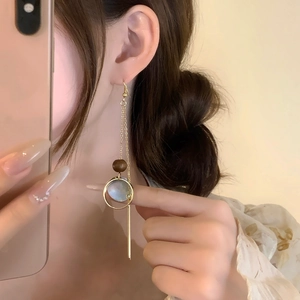 Ethnic vintage tassel earrings with wooden beads and black shell worn in mirror selfie