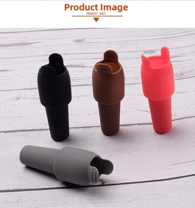 Silicone wine stoppers with handles in four colors on a light wood background
