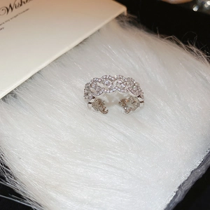 Macro shot of silver-plated heart-shaped open ring with cubic zirconia on white fur