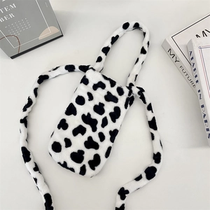 Detailed view of the soft cow pattern plush water bottle bag with a matching shoulder strap