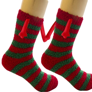 Dettaglio di calze natalizie in pile corallo a righe rosse e verdi su gambe di manichino