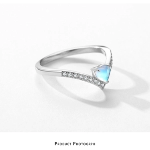 Close-up of heart-shaped blue moonstone ring with sparkling side stones in silver
