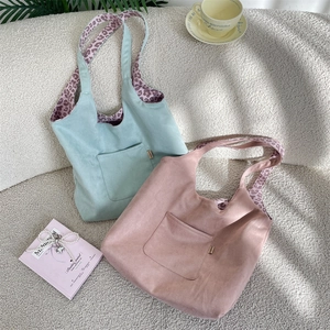 Detail of suede tote bags in mint and dusty pink with stylish leopard print straps