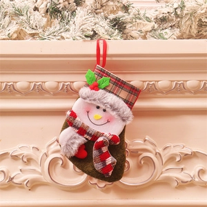 Chaussette de Noël à carreaux verts et bruns avec bonhomme de neige sur une cheminée