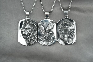 Detailed relief of lion, eagle and cobra motifs on silver steel rectangular pendants