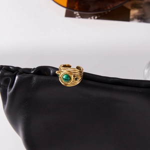 Detail of 18K gold stainless steel ring with malachite on black leather background
