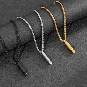 Three bullet pendant necklaces in black, silver and gold with rope chains on dark background