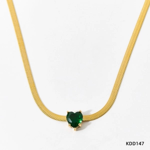Close-up of heart-shaped green emerald zircon pendant on a flat golden snake chain