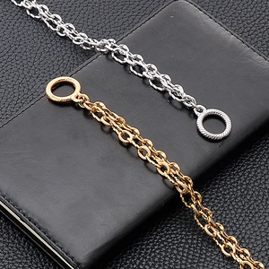 Detail of gold and silver double-layered stainless steel bracelets with OT buckle on black leather