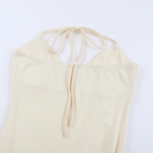 Detail of beige halter dress showing delicate back tie-up design and soft mesh fabric