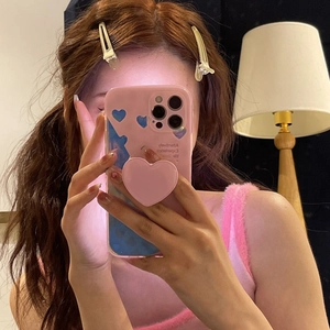 Pink heart pattern phone case with heart-shaped pop socket grip shown in mirror selfie