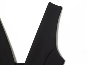 Détail de robe noire à col en V avec larges bretelles et tissu en mélange épais
