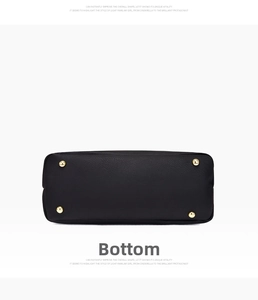 Close-up of black lychee leather handbag bottom with four gold protective metal feet