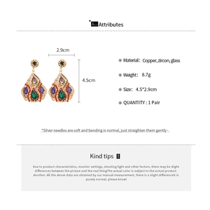 Macro shot of elegant drop-shaped crystal earrings with colorful zircon and copper details