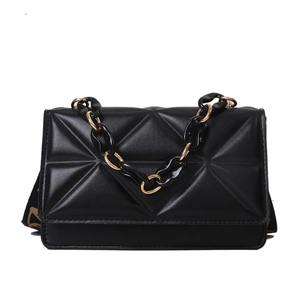 Minimalist black quilted small square bag with geometric texture and gold chain strap