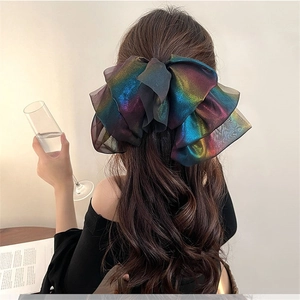 Close-up of a large iridescent mesh bow hair clip with elegant gradient shimmer