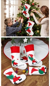 Four Nordic style red and white embroidered Christmas stockings on a wooden floor