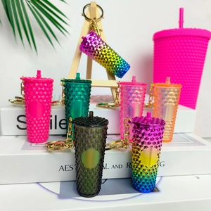 Miniature colorful coffee cup keychain collection with metallic rings on a white background
