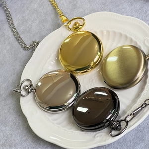 Collection of four vintage pocket watches in gold, silver, bronze and black on a white plate