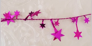 Detail of pink star tinsel garland with metallic glitter finish for Christmas decoration