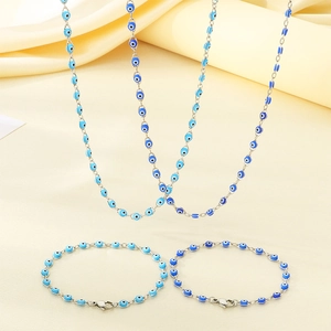 Detailed view of silver Nazar eye jewelry set with blue beads on yellow silk fabric