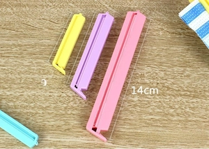 Set of 12 food sealing clips in 14cm, 9cm, and 6.5cm sizes on a wooden background