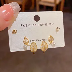 Detailed close-up of S925 silver leaf earrings set with pearls and sparkling zircons
