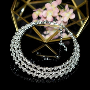 Close-up of elegant silver multi-layer rhinestone necklace on reflective black background