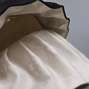 Macro detail of satin jacquard floral pattern and woven texture on wide brim sun hat