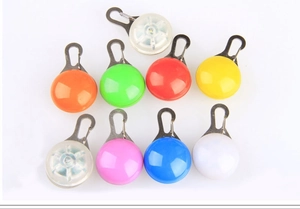 Macro detail of multi-color LED pet safety pendants with metal clips for night visibility