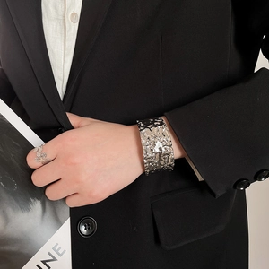 Detailed shot of a textured wide silver bangle with hammered liquid metal finish