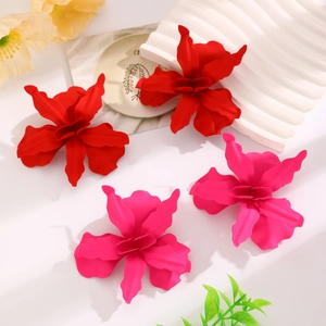 Detail of matte floral earrings in red and pink with pleated layered petal texture