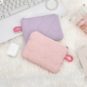 Close-up of pink and purple quilted pouches on a soft white texture for daily storage