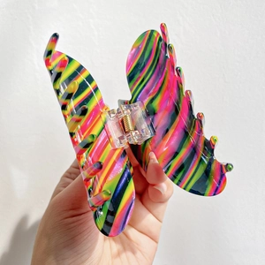 Macro shot of large butterfly hair claw clip with vibrant colorful swirl textures