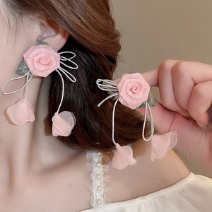 Detailed view of pink mesh fabric rose earrings with delicate floral petal textures