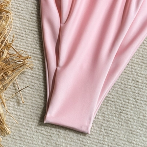 Detail view of pink satin swimsuit fabric with clean stitching and high elasticity