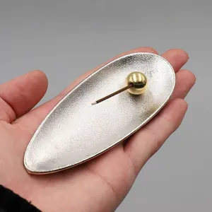 Close-up of silver-plated water droplet incense burner with golden sphere holder