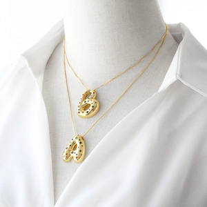 Double-layered gold letter A and B necklaces with colorful zircon stones on a mannequin