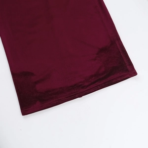 Detailed close-up of the fine stitching on the burgundy velvet dress hemline