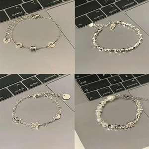 Detailed views of four silver charm bracelets with pearls and geometric pendants