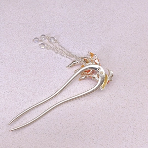 Detailed shot of golden koi fish hair stick with orange enamel and tassel beads