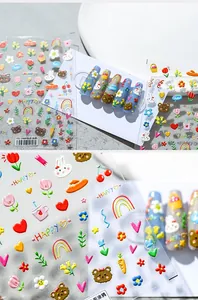 Vista macro di adesivi nail art 3D in rilievo con cuori e fiori colorati a cartone