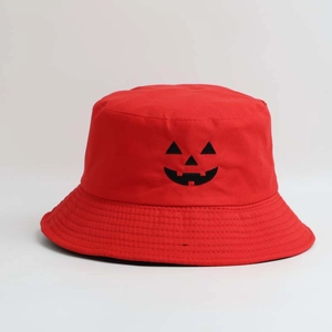 Detailed view of red cotton bucket hat featuring a black Jack-o'-lantern pumpkin face