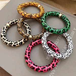Macro detail of retro leopard print resin bracelets with golden metal beads stack