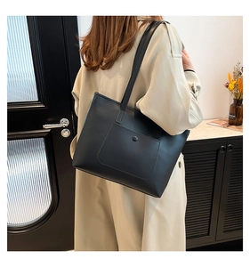 Détail du sac cabas noir minimaliste avec poche à rabat et bouton pression métallique aimanté