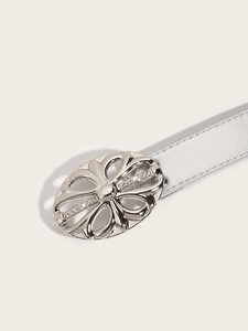 Detail of silver belt featuring a hollow floral oval buckle set with sparkling rhinestones